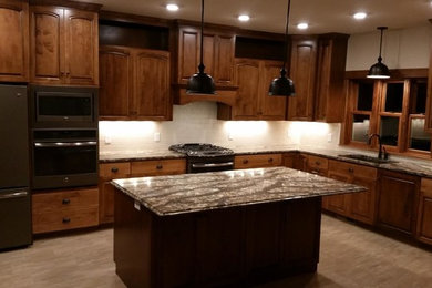 Inspiration for a large craftsman l-shaped kitchen remodel in Orange County with recessed-panel cabinets, medium tone wood cabinets, white backsplash, subway tile backsplash, stainless steel appliances and an island