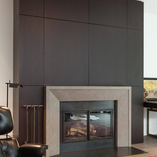 Idéer för mellanstora funkis separata vardagsrum, med en standard öppen spis, en spiselkrans i trä, en dold TV, vita väggar, ljust trägolv och brunt golv