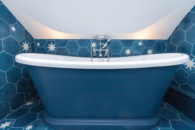 ロンドンにあるお手頃価格の小さなトラディショナルスタイルのおしゃれな子供用バスルーム (青いキャビネット、置き型浴槽、分離型トイレ、青いタイル、青い壁、青い床、洗面台1つ、独立型洗面台) の写真