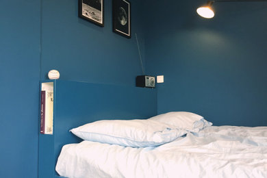 Cette image montre une chambre d'enfant minimaliste de taille moyenne avec un mur bleu et parquet clair.