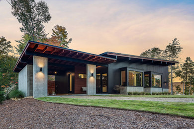 Small contemporary one-story mixed siding house exterior idea in Other with a shed roof and a metal roof
