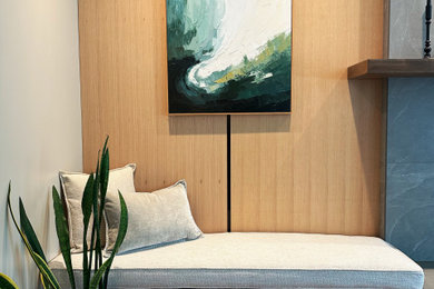 Mid-sized minimalist enclosed medium tone wood floor, brown floor and wood wall family room photo in Other with beige walls, a standard fireplace, a tile fireplace and a wall-mounted tv