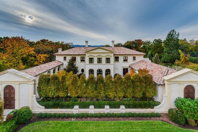 Huge traditional white two-story stucco gable roof idea in Nashville
