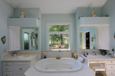 Mid-sized elegant master ceramic tile drop-in bathtub photo in Cleveland with a drop-in sink, raised-panel cabinets, white cabinets and blue walls