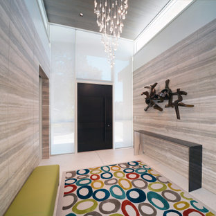 Immagine di una grande porta d'ingresso minimal con pareti beige, pavimento alla veneziana, una porta a pivot, una porta in metallo e pavimento beige