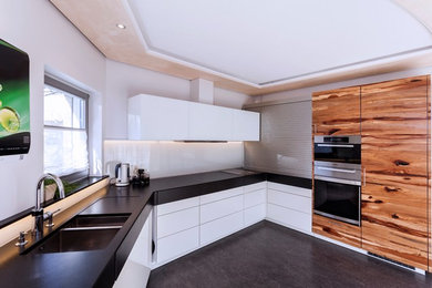 Mittelgroße, Offene, Einzeilige Moderne grifflose Küche ohne Insel mit flächenbündigen Schrankfronten, weißen Schränken, Mineralwerkstoff-Arbeitsplatte, Küchenrückwand in Weiß, Glasrückwand, Einbauwaschbecken, Küchengeräten aus Edelstahl und Linoleum in München