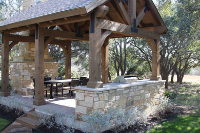 Example of a mid-sized classic backyard stone patio kitchen design in Austin with a gazebo