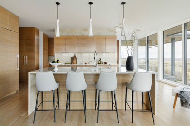 Design ideas for a large contemporary l-shaped eat-in kitchen in Calgary with an undermount sink, flat-panel cabinets, light wood cabinets, quartzite benchtops, white splashback, stone slab splashback, panelled appliances, light hardwood floors, with island, beige floor and white benchtop.