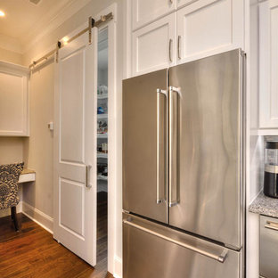 This is an example of a large transitional l-shaped kitchen pantry in Other with an undermount sink, shaker cabinets, white cabinets, granite benchtops, grey splashback, matchstick tile splashback, stainless steel appliances, medium hardwood floors, with island, brown floor and grey benchtop.