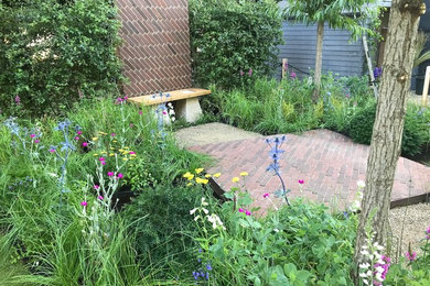 Photo of a small country full sun garden in London with brick pavers.