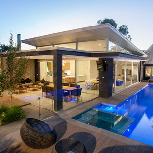 Idéer för att renovera ett stort funkis grått hus i flera nivåer, med platt tak