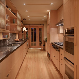 Inspiration for a small modern galley kitchen pantry in Seattle with an undermount sink, light wood cabinets, limestone benchtops, panelled appliances, light hardwood floors and no island.