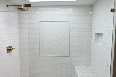 他の地域にある広いトランジショナルスタイルのおしゃれなマスターバスルーム (アルコーブ型シャワー、白いタイル、セラミックタイル、セラミックタイルの床、グレーの床、シャワーベンチ) の写真