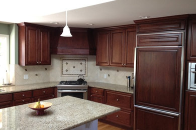 Example of a mid-sized transitional u-shaped light wood floor and brown floor eat-in kitchen design in San Francisco with a drop-in sink, raised-panel cabinets, dark wood cabinets, granite countertops, beige backsplash, ceramic backsplash, stainless steel appliances and an island