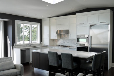Example of a mid-sized trendy l-shaped dark wood floor open concept kitchen design in Vancouver with an undermount sink, shaker cabinets, white cabinets, quartz countertops, gray backsplash, stone tile backsplash, stainless steel appliances and an island