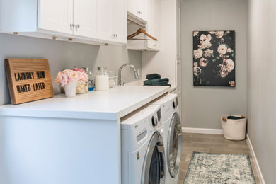 Design ideas for a mid-sized contemporary galley dedicated laundry room in Houston with an undermount sink, shaker cabinets, white cabinets, quartz benchtops, grey walls, porcelain floors, a side-by-side washer and dryer, grey floor and white benchtop.