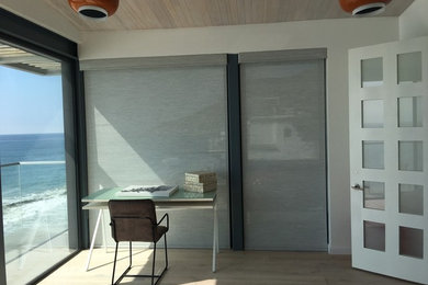 Study room - mid-sized contemporary freestanding desk light wood floor and brown floor study room idea in San Diego with beige walls