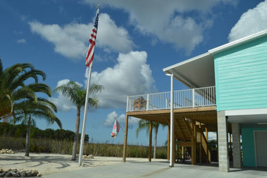 Example of a beach style deck design in Tampa with a roof extension