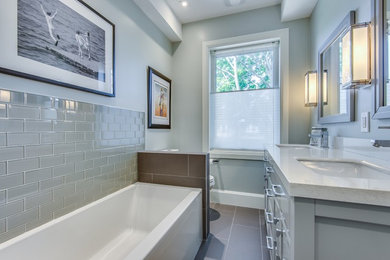 Bathroom - mid-sized transitional kids' green tile and glass tile porcelain tile and gray floor bathroom idea in Toronto with furniture-like cabinets, gray cabinets, a two-piece toilet, gray walls, an undermount sink, quartz countertops and a hinged shower door