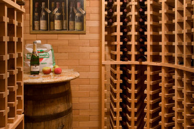 Inspiration for a large traditional wine cellar in Boston with brick floors and storage racks.