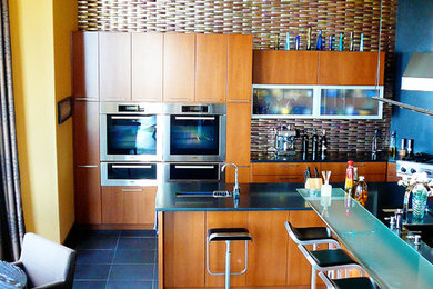 Inspiration for a large contemporary l-shaped porcelain tile eat-in kitchen remodel in Other with an undermount sink, flat-panel cabinets, medium tone wood cabinets, granite countertops, multicolored backsplash, glass tile backsplash, stainless steel appliances and an island