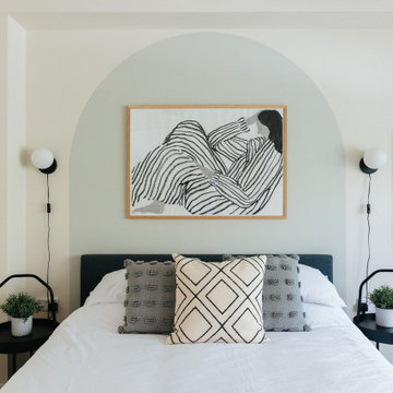 Calming guest bedroom with painted arch headboard