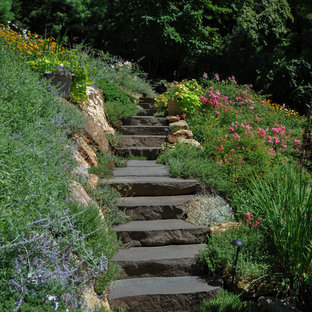 Mid-sized traditional sloped full sun formal garden in New York with natural stone pavers and with rock feature for summer.
