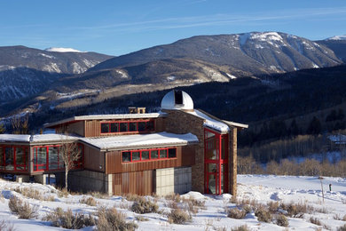 Example of a huge minimalist brown three-story mixed siding exterior home design in Denver with a clipped gable roof
