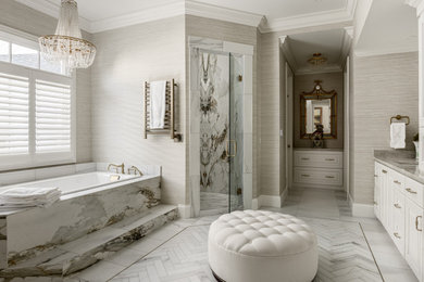 Large elegant master porcelain tile marble floor, white floor, double-sink and wallpaper bathroom photo in Nashville with raised-panel cabinets, white cabinets, beige walls, an undermount sink, a hinged shower door, beige countertops and a built-in vanity