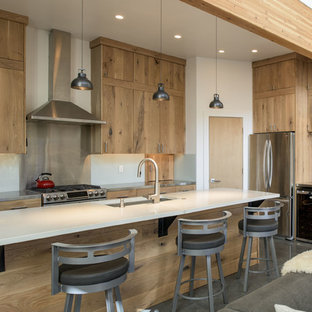 Rustic open concept kitchen designs - Open concept kitchen - rustic concrete floor and gray floor open concept kitchen idea in Boise with an undermount sink, flat-panel cabinets, light wood cabinets, metallic backsplash, stainless steel appliances, an island and white countertops