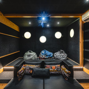 Inspiration for a world-inspired enclosed home cinema in Ahmedabad with black walls, medium hardwood flooring and brown floors.