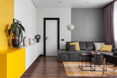 Foto de salón abierto y gris y blanco minimalista de tamaño medio sin chimenea con paredes amarillas, suelo de madera oscura, suelo marrón, papel pintado y alfombra