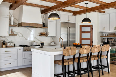 ワシントンD.C.にある広いカントリー風のおしゃれなキッチン (白いキャビネット、白いキッチンパネル、シルバーの調理設備、淡色無垢フローリング、白いキッチンカウンター) の写真