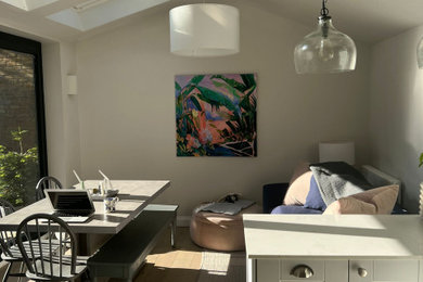Design ideas for a medium sized nautical grey and white kitchen in London with a belfast sink, shaker cabinets, grey cabinets, quartz worktops, white splashback, stone slab splashback, integrated appliances, light hardwood flooring, a breakfast bar, brown floors, white worktops, a drop ceiling and a feature wall.