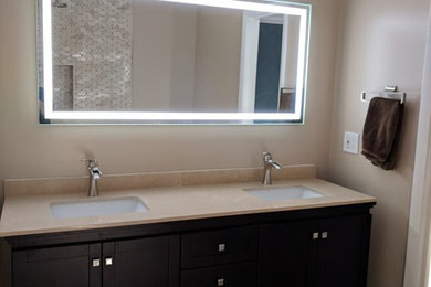 Mid-sized trendy master beige tile and travertine tile porcelain tile and beige floor bathroom photo in Miami with recessed-panel cabinets, black cabinets, a two-piece toilet, beige walls, an undermount sink and quartzite countertops