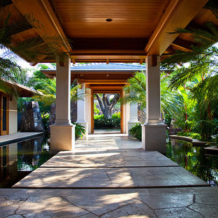 Design ideas for a mid-sized tropical courtyard partial sun garden in Hawaii with with pond and natural stone pavers.