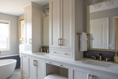Example of a mid-sized transitional master porcelain tile, white floor and double-sink freestanding bathtub design in Minneapolis with shaker cabinets, white cabinets, white walls, a drop-in sink, quartzite countertops, white countertops, a niche and a built-in vanity