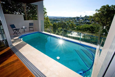 Photo of a small modern rectangular aboveground pool in Brisbane with tile.