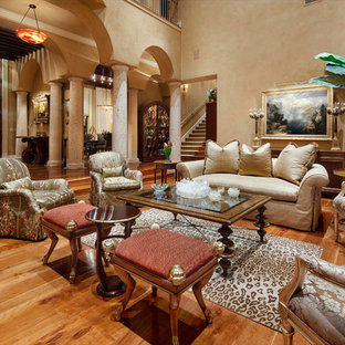 Großes Mediterranes Wohnzimmer mit beiger Wandfarbe und braunem Holzboden in Austin