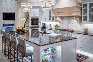Example of a large transitional u-shaped limestone floor and beige floor eat-in kitchen design in Houston with an undermount sink, flat-panel cabinets, white cabinets, quartzite countertops, beige backsplash, limestone backsplash, an island and black countertops