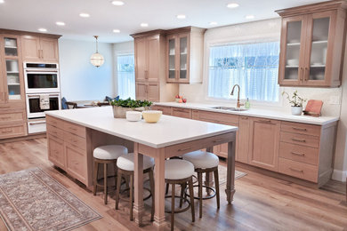 Kitchen - large traditional kitchen idea in Salt Lake City with recessed-panel cabinets, glass tile backsplash, white appliances and an island