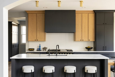 Photo of an expansive transitional l-shaped eat-in kitchen in Minneapolis with an undermount sink, shaker cabinets, grey cabinets, quartz benchtops, white splashback, subway tile splashback, stainless steel appliances, medium hardwood floors, multiple islands, brown floor and white benchtop.