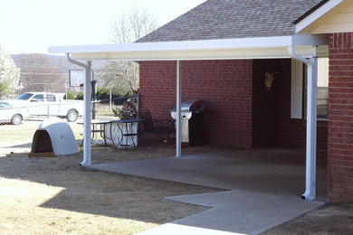 Inspiration for a large modern backyard patio remodel in Other with an awning