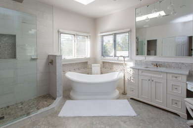 Large transitional master bathroom in DC Metro with shaker cabinets, white cabinets, a freestanding tub, a corner shower, an undermount sink, marble benchtops, gray tile, porcelain tile, white walls, porcelain floors, grey floor and an open shower.