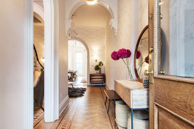 Transitional light wood floor and brown floor entryway photo in New York with white walls and a medium wood front door