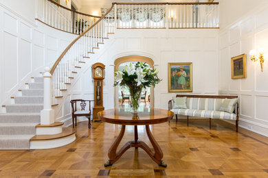 This is an example of a large traditional entryway in New Orleans with beige walls, dark hardwood floors and brown floor.