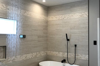 Inspiration for a modern master gray tile and stone slab limestone floor and beige floor bathroom remodel in Houston with recessed-panel cabinets, white cabinets, gray walls, an undermount sink, solid surface countertops and white countertops