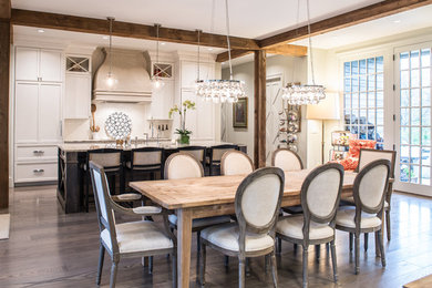 Example of a transitional galley light wood floor kitchen design in St Louis with a farmhouse sink, recessed-panel cabinets, beige cabinets, white backsplash, subway tile backsplash, white appliances and an island