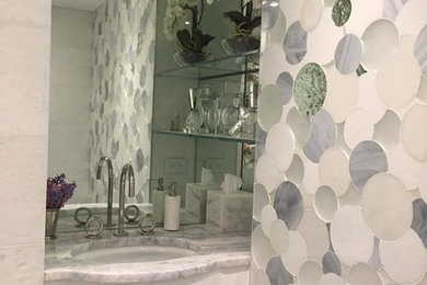 This is an example of a small contemporary 3/4 bathroom in San Diego with white cabinets, gray tile, white tile, white walls, an undermount sink and marble benchtops.