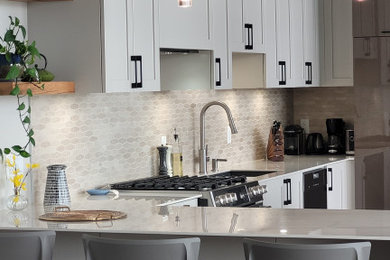 Foto de cocina minimalista pequeña con salpicadero beige, electrodomésticos de acero inoxidable y encimeras blancas